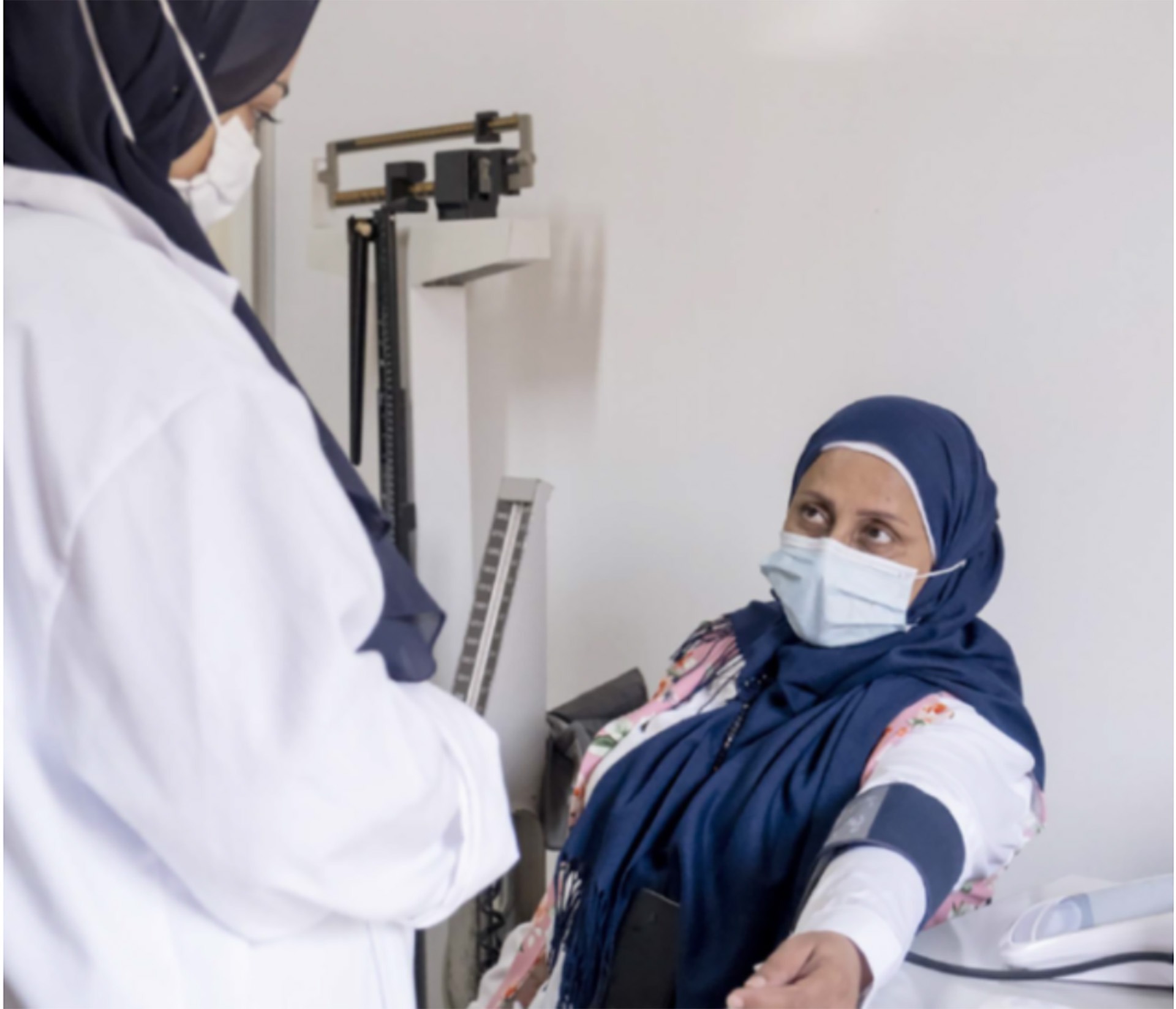 hypertension-news two people wearing masks and a headscarfs taking blood pressure